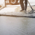 Workman doing road surface concrete pouring job in construction site